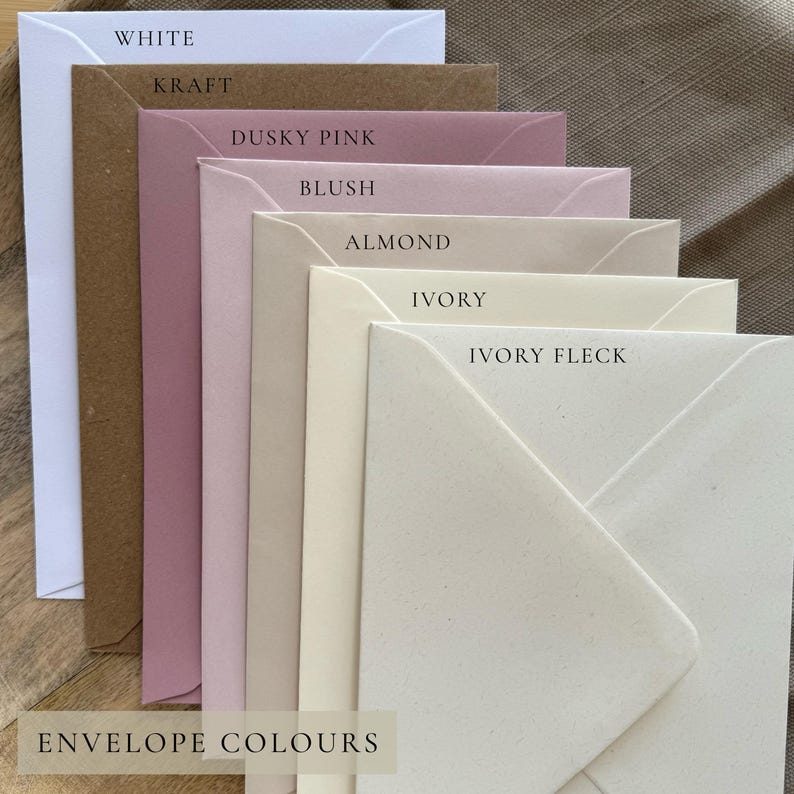 May include: A stack of envelopes in various colors, including white, kraft, dusky pink, blush, almond, ivory, and ivory fleck. The text "ENVELOPE COLOURS" is at the bottom. The envelopes are arranged in a layered fashion.