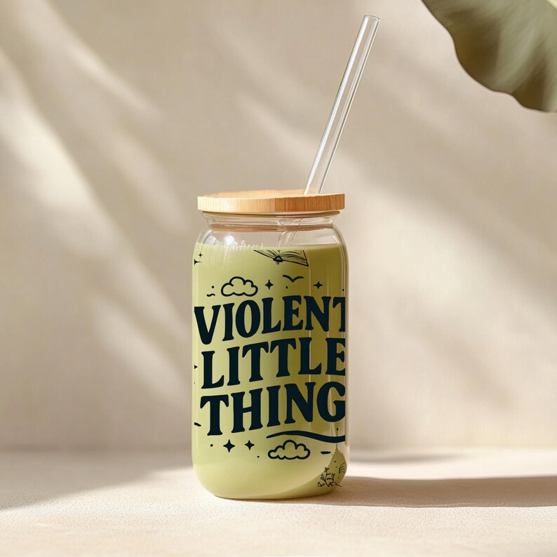 Puede incluir: Un tarro de vidrio con tapa de madera y una pajita. El tarro est&aacute; lleno de un l&iacute;quido verde y tiene el texto "VIOLENT LITTLE THING" impreso en &eacute;l.