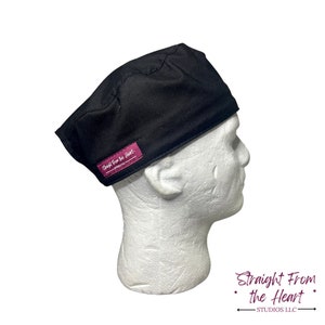 Peut inclure: Casquette de chirurgien noire avec une étiquette magenta. L'étiquette indique "Straight From the Heart" en écriture blanche. Le bonnet est présenté sur une tête de mannequin blanche. Conçu pour un usage médical.