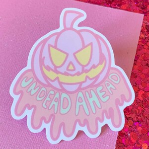 May include: A pink and green sticker with a dripping, melting pumpkin and the text "Undead Ahead".