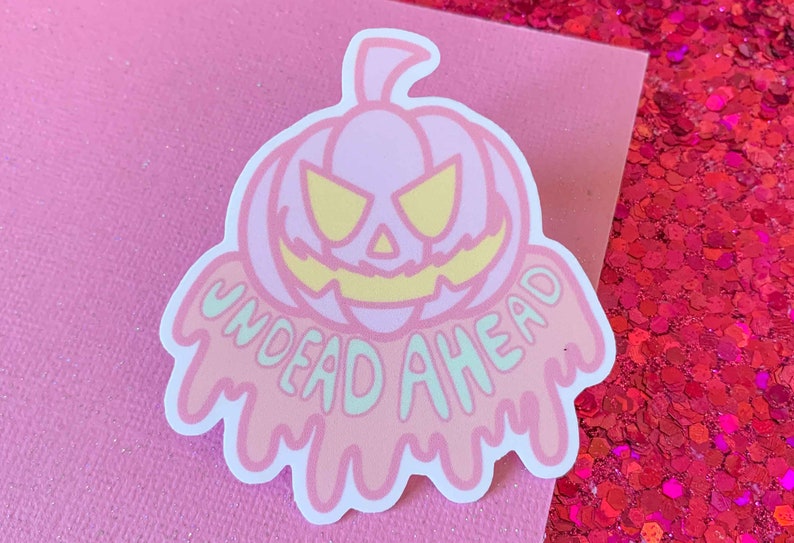 May include: A pink and green sticker with a dripping, melting pumpkin and the text "Undead Ahead".