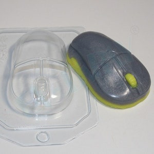 May include: A clear plastic mold for making a computer mouse shaped soap. The mold is next to a gray and yellow computer mouse shaped soap.