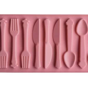 May include: Pink silicone mold with 10 cavities shaped like forks, knives, and spoons.