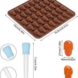 May include: A brown silicone mold with 48 skull-shaped cavities. The mold measures 6.3 inches by 6.6 inches. Two clear droppers with blue tops are shown. Two orange skull-shaped candies are shown, one measuring 0.62 inches wide and the other measuring 0.3 inches wide.