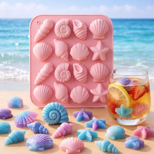 May include: A pink silicone mold filled with seashell and starfish shapes, alongside colorful ice cubes in the same designs. A glass of iced beverage with fruit and a seashell ice cube is also present. The scene is set against a beach backdrop.