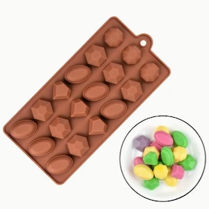 May include: Brown silicone mold with 16 cavities shaped like diamonds and ovals. The mold is filled with colorful candy shaped like diamonds and ovals.
