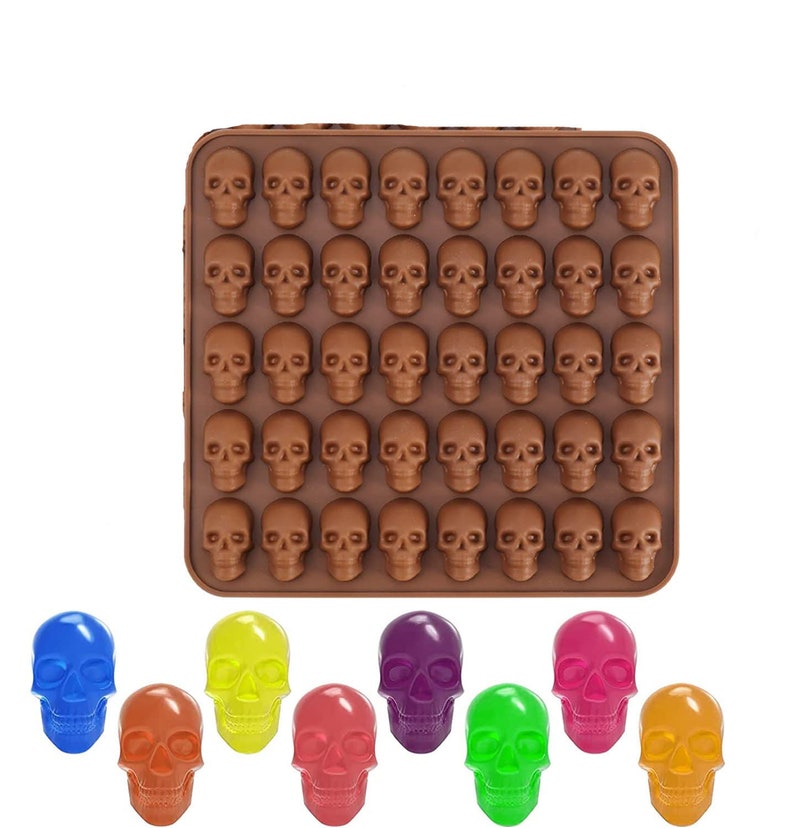 May include: A brown silicone mold with 48 skull-shaped cavities. The mold is filled with colorful candy skulls in blue, yellow, purple, pink, green, and orange.