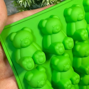 May include: Green silicone mould with multiple bear-shaped cavities. The mould is designed for making small, detailed bear-shaped sweets, chocolates, or other treats.