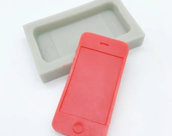 May include: A red silicone mold shaped like a smartphone. The mold is used to create a replica of a smartphone.