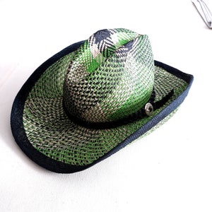 May include: A green and black woven straw cowboy hat with a black band and a silver button.