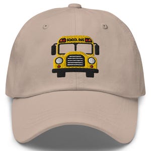 May include: A beige baseball cap with an embroidered yellow school bus with the words "School Bus" on the front.