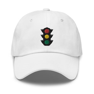 May include: White baseball cap featuring an embroidered traffic light design. The traffic light has a red light at the top, a yellow light in the middle, and a green light at the bottom.