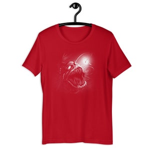 K&ouml;nnte beinhalten: Rotes T-Shirt mit einem wei&szlig;en Grafikdruck eines Tiefsee-Anglerfisches mit einer biolumineszierenden Leuchtangel.