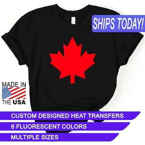May include: Black t-shirt with a red maple leaf design. The shirt says "SHIPS TODAY!" in a blue box at the top. The text "MADE IN THE USA" is in a red, white, and blue box at the bottom left. The text "CUSTOM DESIGNED HEAT TRANSFERS", "6 FLUORESCENT COLORS", and "MULTIPLE SIZES" are in blue boxes at the bottom.