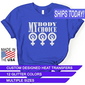 May include: Blue t-shirt with the text "My Body My Choice" in white with three white female symbols with raised fists. The shirt is made in the USA and is available in multiple sizes and 12 glitter colors.
