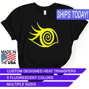 May include: Black t-shirt with a yellow eye graphic. The text "SHIPS TODAY!" is in a blue box in the upper right corner. The text "MADE IN THE USA" is in a red, white, and blue box in the lower left corner. The text "CUSTOM DESIGNED HEAT TRANSFERS", "6 FLUORESCENT COLORS", and "MULTIPLE SIZES" are in a purple box at the bottom of the image.