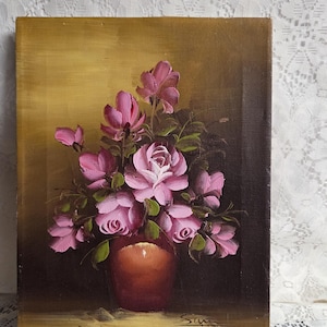 May include: Oil painting depicting pink roses and other flowers in a brown vase. The flowers have green leaves and are set against a dark background with a gold-toned upper section. The painting is signed "Sam" in the lower right corner.