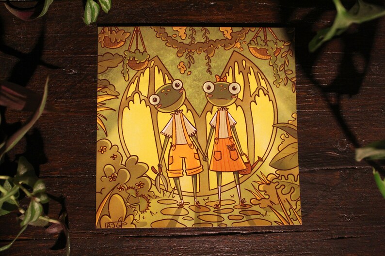May include: Two green frog characters with large eyes and orange clothing stand in a yellow and green forest setting. The frog on the left holds gardening shears and the frog on the right holds a watering can. The background features a large yellow archway with hanging plants.