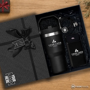 May include: A black gift box containing a matte black insulated tumbler with a handle, a black power bank with a digital display showing 100%, and a black charging cable. The box lid features a black ribbon bow and a tag reading Just For You.