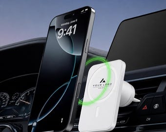 Peut inclure: Un smartphone noir fixé sur un chargeur de voiture magnétique blanc attaché à une grille d'aération. Le chargeur présente un anneau lumineux vert circulaire et le texte "YOUR LOGO HERE" sur sa face avant. Le logo MobilMoods est visible en haut.
