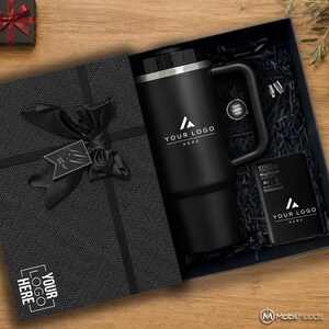 May include: A black gift box containing a black travel mug with a handle, a black 10000mAh MagCharge power bank, and a charging cable. The box features a black ribbon bow, a tag with the text Just For You, and the text YOUR LOGO HERE on the lid.