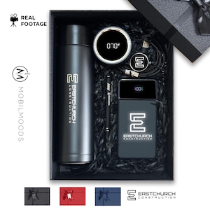 Può includere: Una confezione regalo nera contenente una bottiglia d'acqua isolata nera, un caricabatterie portatile, uno smartwatch, una penna e un cavo di ricarica. Gli articoli hanno il logo "EASTCHURCH CONSTRUCTION". L'orologio mostra 21.1°C. Il caricabatterie mostra 100%.