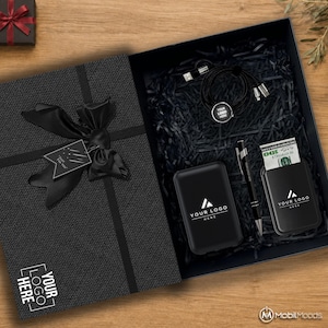 Peut inclure: Un coffret cadeau noir contenant une batterie externe noire, un stylo noir, un câble de charge noir et un porte-cartes noir avec un billet de cent dollars. Le couvercle présente un nœud en ruban noir, une étiquette Just For You et Your Logo Here.