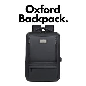 Könnte beinhalten: Ein schwarzer Rucksack mit dem Text Oxford Backpack darüber. Die Tasche hat eine rechteckige Form, zwei vertikale Reißverschlussfächer auf der Vorderseite, einen Tragegriff, Schultergurte und eine rechteckige Metall-Logoplakette mit dem Text YOUR LOGO.