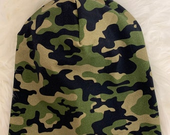 May include: A camouflage beanie hat in shades of green, brown, and black. The hat is made of a soft fabric and is designed to fit snugly on the head. The pattern is a classic military-style camouflage.