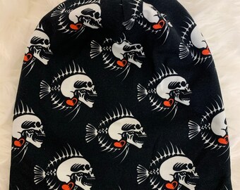 May include: Black beanie with a white skull and fishbone pattern. The skulls have red hearts on them.