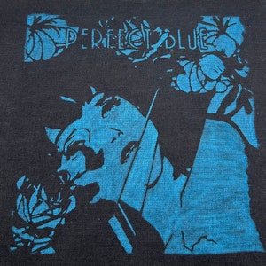 May include: A black and blue iron-on patch with the text "PERFECT BLUE" in white lettering. The patch features a stylized image of a woman's face.