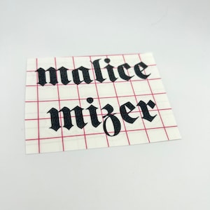 Puede incluir: Pegatina de vinilo negro con las palabras "malice mizer" en una fuente gótica.