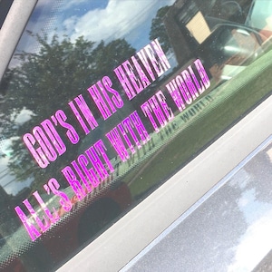 May include: A pink vinyl sticker on a car window that reads "God's in His Heaven All's Right With The World".