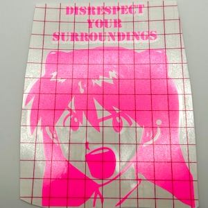 May include: A pink sticker with the words "DISRESPECT YOUR SURROUNDINGS" above a pink anime-style character with an open mouth. The sticker has a grid pattern and is on a white background.