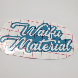 May include: A white sticker with a blue graphic that says "Waifu Material" on a white gridded background.