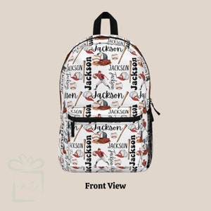 May include: White backpack with a baseball theme. The backpack is covered in a repeating pattern of baseball bats, baseballs, baseball caps, and the name "Jackson".