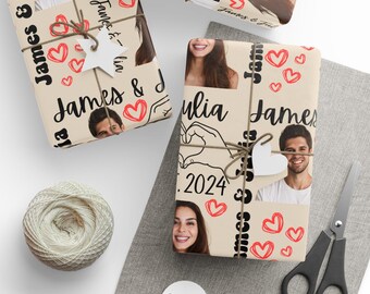 Könnte beinhalten: Geschenkpapier mit Fotos eines Paares, Namen und dem Jahr 2024. Das beige Papier ist mit roten Herzen verziert und mit Bindfaden gebunden. Eine Garnrolle, eine Schere und Etiketten sind ebenfalls sichtbar.