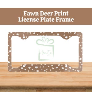 May include: A brown license plate frame with a white fawn print. The frame is made of metal and has a glossy finish.
