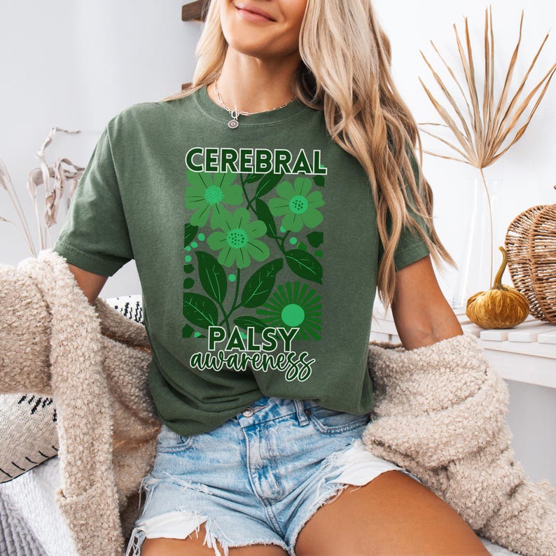 May include: A woman wearing a green t-shirt with the text "Cerebral Palsy awareness" and a floral design in green and white.