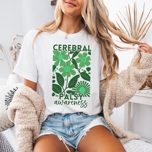 May include: White t-shirt with a green floral design and the text "Cerebral Palsy awareness".