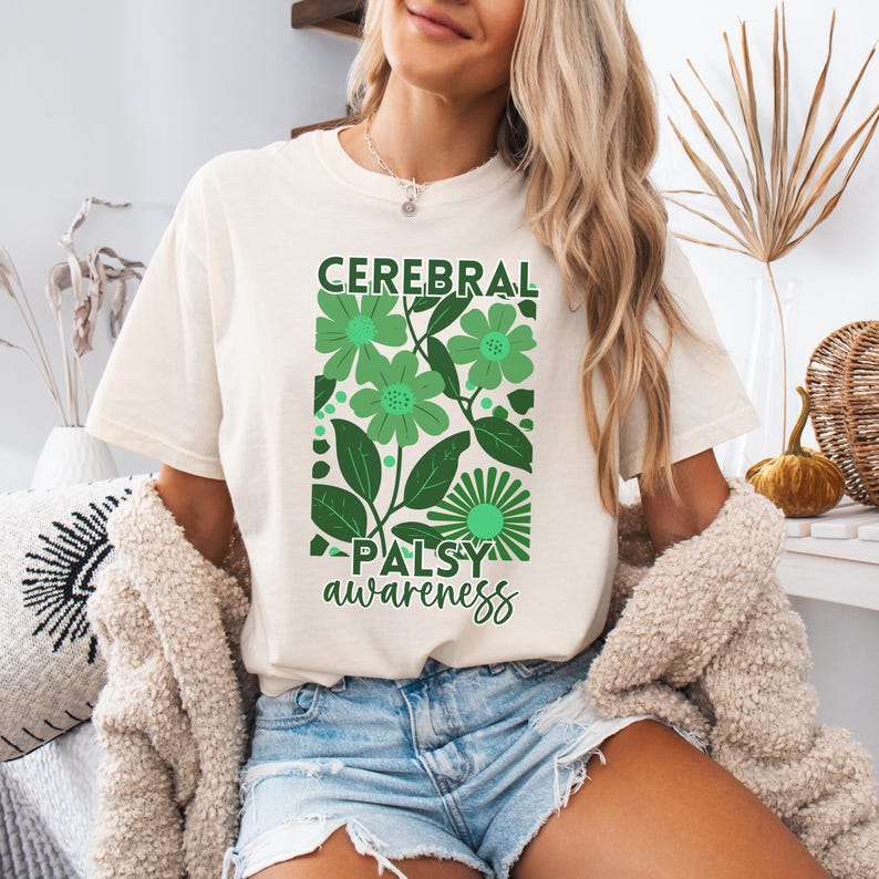 May include: A white t-shirt with a green floral design and the text "Cerebral Palsy awareness".