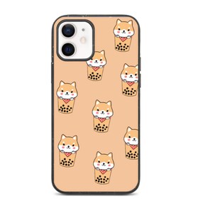 May include: A peach-coloured phone case with a black border and a repeating pattern of cartoon Shiba Inu dogs holding boba tea cups. The case has a cutout for the phone camera.