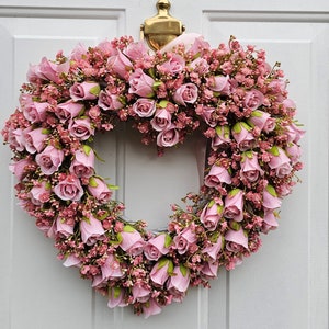 Corona rosa en forma de corazón para puerta de entrada con rosas artificiales y gypsophila.