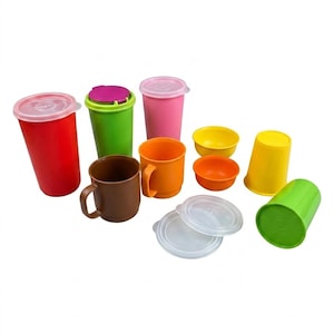 May include: A collection of colorful plastic kitchenware including tall tumblers with lids in red, green, and pink, a brown mug, an orange mug, two small bowls in yellow and orange, a yellow tumbler, and a green tumbler with two clear lids.