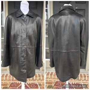 May include: A dark brown leather coat with a button closure and a collar. The coat has long sleeves and a tailored fit. The image shows both the front and back of the coat, highlighting the stitching details and overall design. The coat is displayed on a mannequin.