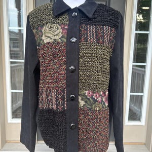 May include: A long-sleeved button-down jacket featuring a patchwork design on the front. The garment combines solid black suede-like panels with textured knit sections and floral tapestry fabric in shades of red, green, and black.