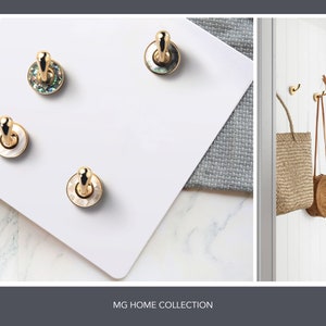 May include: Four gold hooks with a white or iridescent shell design. The hooks are on a white surface. The text "MG HOME COLLECTION" is at the bottom of the image.