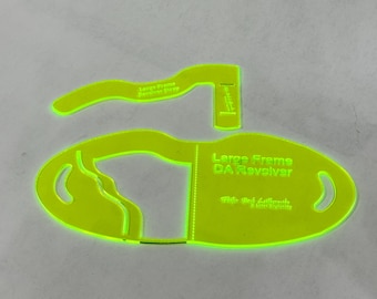 May include: Two neon green quilting templates. One is an oval shape with the text "Large Frame DA Revolver" and the other is a curved shape with the text "Large Frame Revolver Strap".