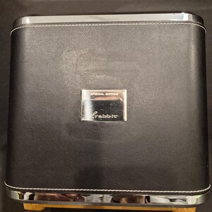 May include: Black leather-effect box with silver trim and white stitching. A silver plate reads "Special Edition" and "Rabbit". The box rests on wooden feet.