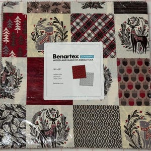 May include: A pack of 10-inch by 10-inch fabric squares featuring a woodland theme. The squares feature various patterns including a plaid, a deer, a rabbit, and acorns. The fabric is by Benartex and is called Woodland Magic by Jessica Fick.